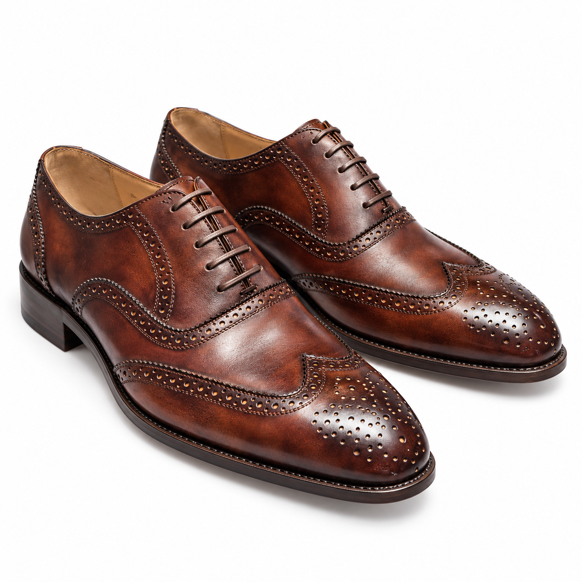 Pair of men's tan hand-burnished leather wingtip brogues, front three-quarter view