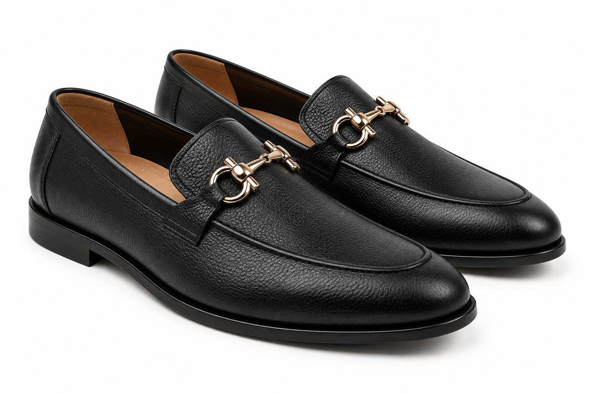 Pair of men's black leather horsebit loafers with gold bit, three-quarter view