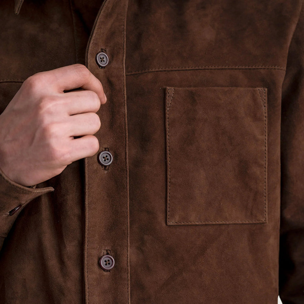 Close-up of the front of the mocha brown suede leather shirt jacket, showing the quality of the suede, buttons, and single chest pocket.