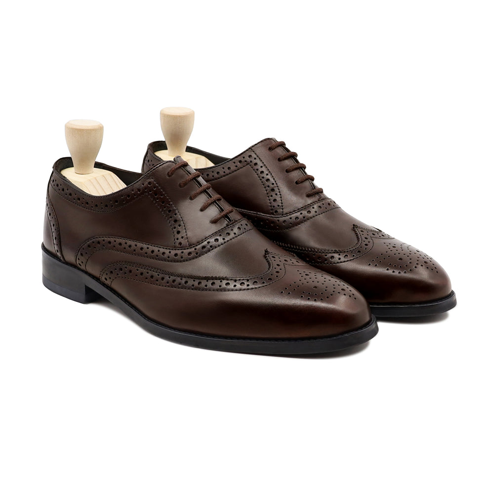 Pair of men's dark brown leather wingtip brogue shoes with shoe trees
